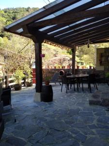 a wooden pergola with a table and chairs on a patio at Casa Llayo in Aliezo