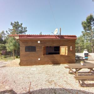 una casa de perros con una mesa de picnic delante de ella en Moinho da Amélia en Cadaval