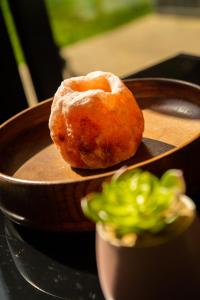 a donut sitting on top of a wooden plate at The Mills Guesthouse Hatfield in Hatfield