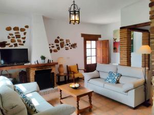 salon z kanapą i kominkiem w obiekcie Villa Huerta Nacimiento w mieście Montecorto
