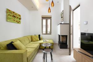 a living room with a green couch and a fireplace at Onirico House in Rhodes Town