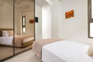 een slaapkamer met 2 bedden en een spiegel bij Onirico House in Rhodos-stad