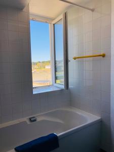 a bath tub in a bathroom with a window at L'Albatros in Perros-Guirec