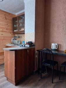uma cozinha com um balcão, uma mesa e cadeiras em Агрба 19/1 Квартира em Pitsunda