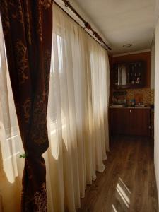 um quarto com cortinas brancas e uma cozinha em Агрба 19/1 Квартира em Pitsunda