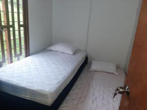 a small bedroom with a bed and a window at Casita familiar de campo condina in Pereira