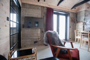 a living room with chairs and a tv and windows at Luxury Cottage in Tórshavn in Tórshavn