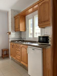 uma cozinha com um frigorífico branco e um micro-ondas em Apartamentos La Proa em Torremolinos
