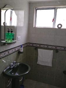 a bathroom with a sink and a mirror at Kaliawiri Bird Lodge & reserve in Villavicencio