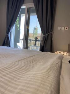 Bett in einem Zimmer mit einem großen Fenster in der Unterkunft Maqeela Luxury Studio in King Abdullah Economic City