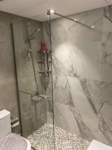 een douche met een glazen deur in de badkamer bij Maqeela Luxury Studio in King Abdullah Economic City