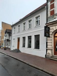 biały budynek po stronie ulicy w obiekcie Drzewna Apartamenty - Kupiecka 5 w Zielonej Górze