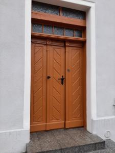 una puerta de garaje marrón en un edificio blanco en Drzewna Apartamenty - Kupiecka, en Zielona Góra