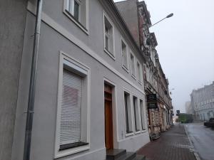 un edificio blanco con ventanas en una calle de la ciudad en Drzewna Apartamenty - Kupiecka, en Zielona Góra