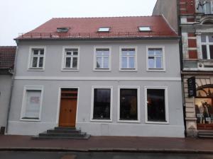 uma casa branca com um telhado vermelho em Drzewna Apartamenty - Kupiecka em Zielona Góra
