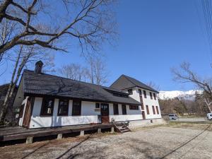 a white house with a black roof at The Joint in Hakuba