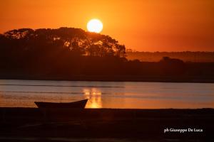 a boat on the shore of a lake at sunset at La Balsa in José Ignacio