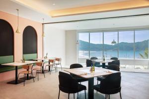 ein Restaurant mit Tischen und Stühlen und Meerblick in der Unterkunft The Week & Resort in Incheon