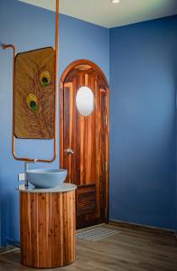 a bathroom with a sink and a wooden door at Eden Home&Cafe in Quy Nhon