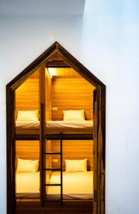 a room with two bunk beds in a wooden house at Eden Home&Cafe in Quy Nhon