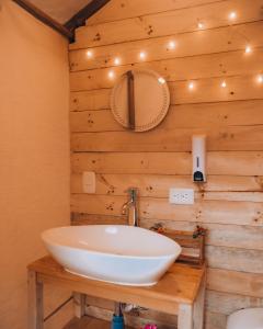 baño con lavabo blanco en una pared de madera en Glamping rio frio Tabio, en Tabio