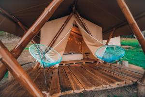 two chairs and a bed in a tent at Glamping rio frio Tabio in Tabio