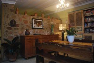 una sala da pranzo con tavolo e parete in pietra di Pousada Flor do Mar a Parati