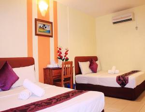 Kampong Batu Lapan的住宿－Sun Inns Tambun，酒店客房设有两张床和一张桌子。