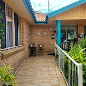 a patio with a brick wall and a skylight at Beaches Serviced Apartments in Nelson Bay