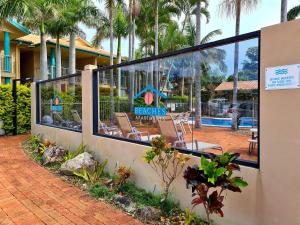 a reflection of a resort with chairs in a window at Beaches Serviced Apartments in Nelson Bay