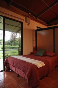 a bedroom with a large bed with a large window at Casa Zu in San Pedro