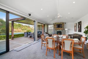 a dining room with a table and chairs and a fireplace at River View Retreat - Taupo in Taupo