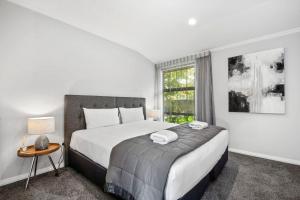 Un dormitorio con una cama grande y una ventana en River View Retreat - Taupo en Taupo