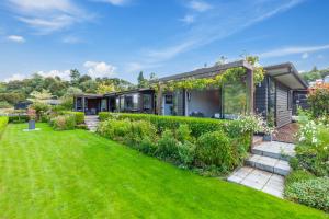 a house with a green yard at River View Retreat - Taupo in Taupo