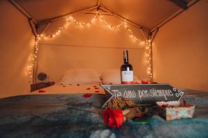 a bed with a bottle of wine and a sign on it at Glamping rio frio Tabio in Tabio