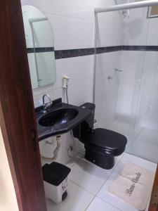 baño con aseo negro y lavamanos en Apartamento Amplo e familiar em frente à Igreja do Céu en Viçosa do Ceará