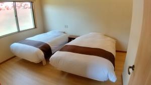 A bed or beds in a room at FUTO HOUSE -Ippon no Enpitsu-