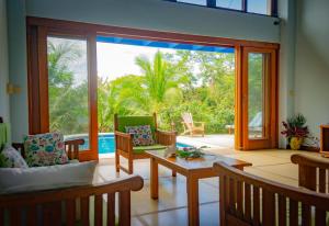 una sala de estar con una gran puerta corredera de cristal en Cañafistula Fourth Dimension en Tamarindo