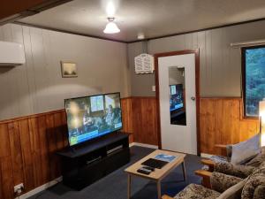 a living room with a flat screen tv and a couch at Roland B&B in Claude Road