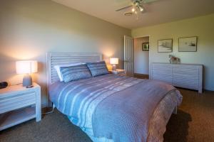 a bedroom with a bed with two night stands and two lamps at 5 Hepburn Lane in Hanmer Springs