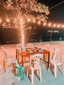 a wooden table with chairs and lights on a patio at Thien Nhan Hotel in Cửa Lò