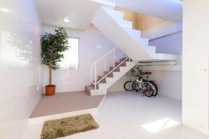 Una escalera blanca en una casa con una planta en Sea Side House Toya, en Lago Toya