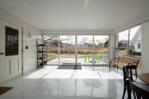 a living room with a door and a table and chairs at Sea Side House Toya in Lake Toya