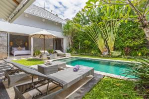 une arrière-cour avec une piscine et une villa dans l'établissement Villa Irma, à Seminyak