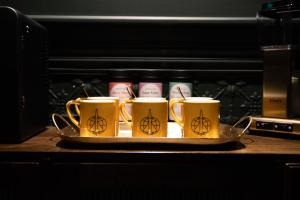 a tray with four coffee mugs on a table at The Intrepid Hotel in Wellington