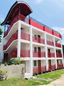 a white and red building with red balconies at RB Baruiz "Hideaway" Inn - Cebu South in Cebu City