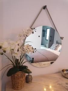 um espelho sobre uma mesa com um vaso de flores em Villa Otivar em Otívar