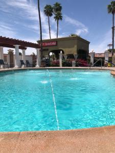 a swimming pool with a fountain in front of a hotel at Econo Lodge in Blythe