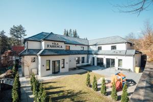 a white house with a blue roof at Vila Fabesca in Sovata