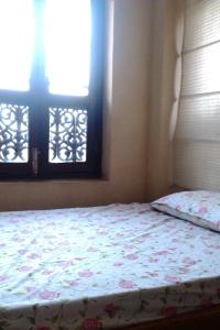 a bedroom with a bed and two windows at Ecotel Guest House in Bhaktapur